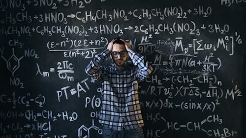 A man standing in front of a blackboard with many formulas