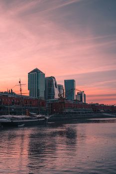 A breathtaking view of Puerto Madero's skyline at sunset reflecting on the waterfront.
