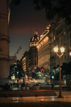 A beautifully lit city street at night showcasing classic architecture and glowing streetlights.
