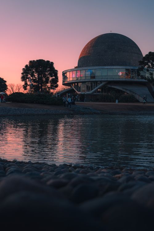 Free Stunning view of the Galileo Galilei Planetarium at sunset in Buenos Aires with a serene lake reflection. Stock Photo