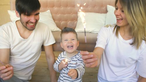 Free Joyful family celebrating with sparklers inside, capturing happy moments. Stock Photo