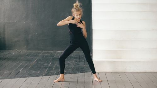 Free Young female dancer poses elegantly in a modern dance studio. Barefoot and expressive, she embodies contemporary dance. Stock Photo