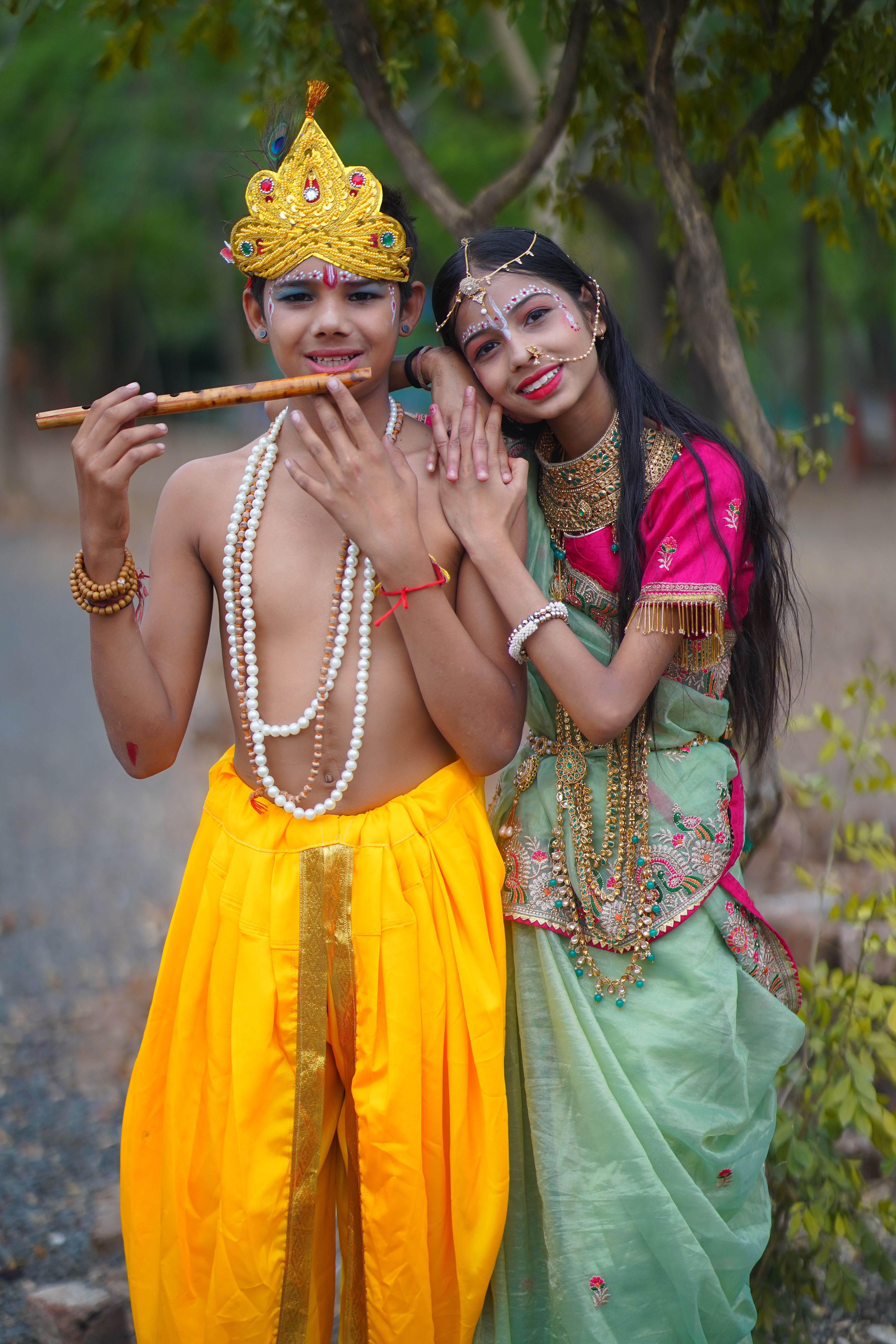 Young couple in traditional Indian attire celebrating a cultural festival outdoors.