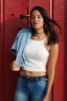 一位时尚前卫的女人穿着牛仔装，在城市环境中户外摆姿势