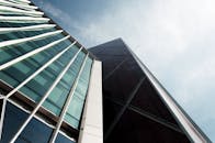 在明亮的天空下，低角度拍摄的英国伦敦现代摩天大楼与玻璃幕墙