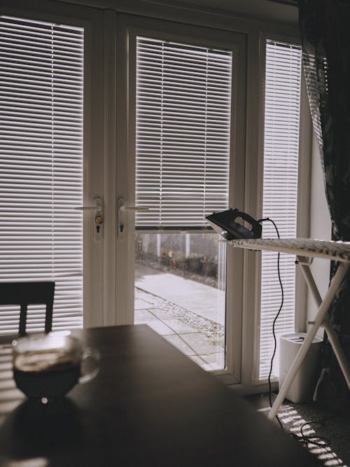 A table with a coffee pot and a window