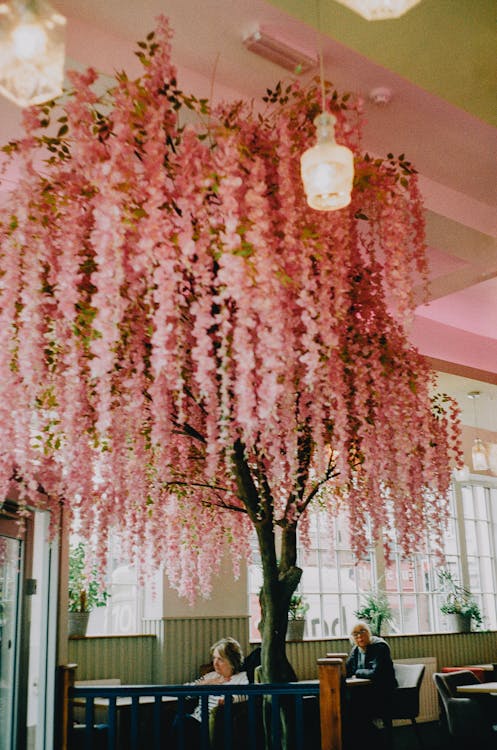 A pink tree is hanging from the ceiling in a restaurant