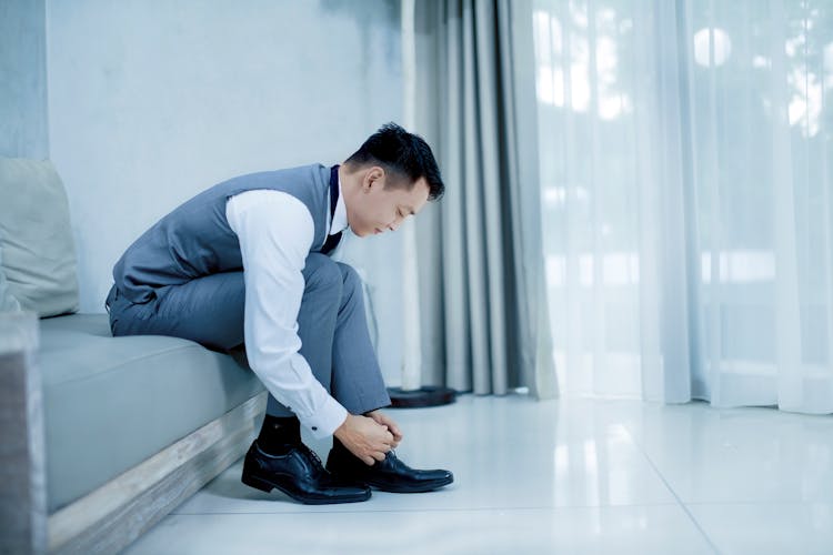 Photo Of Man Tying His Shoes