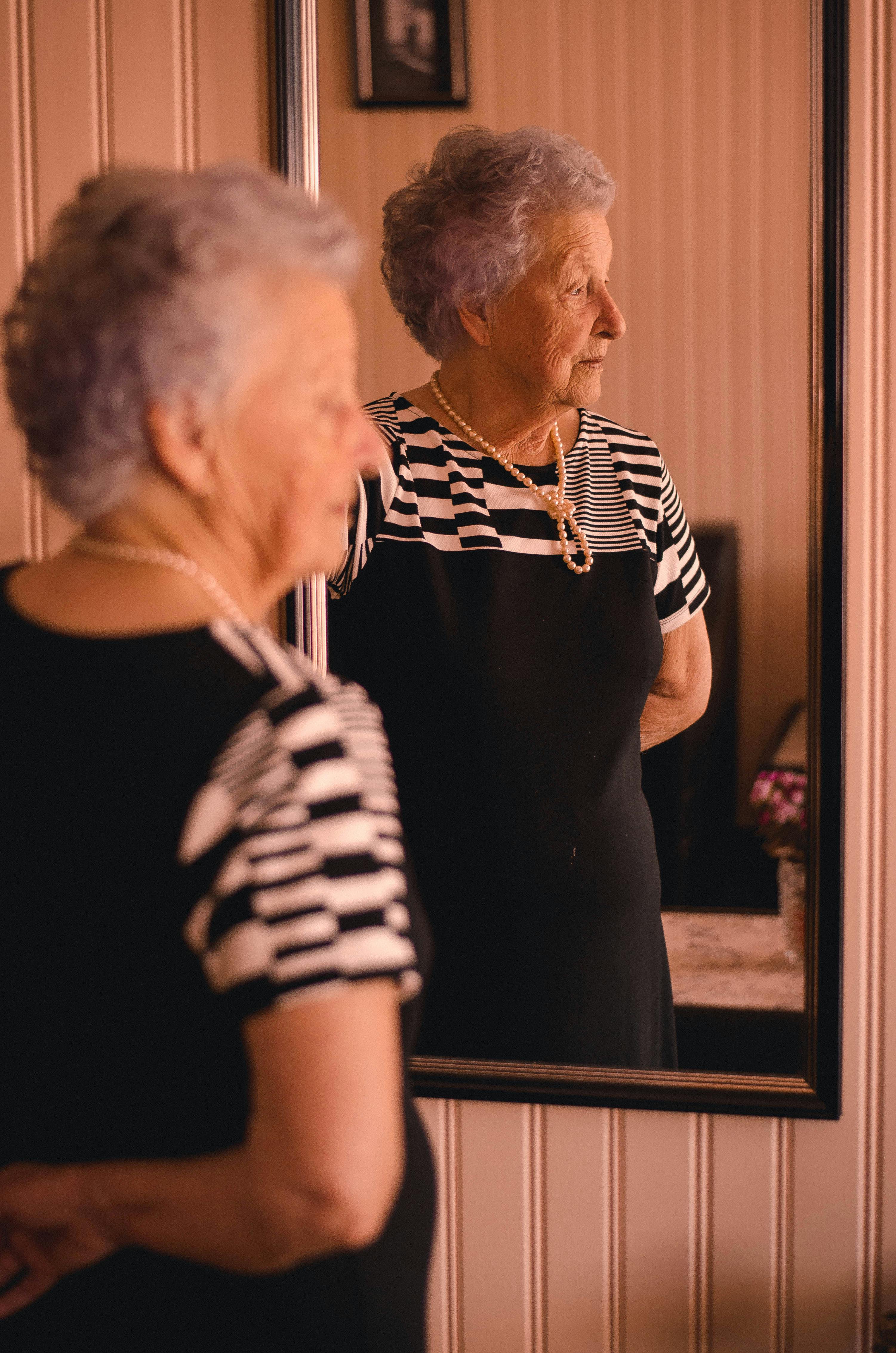 Woman standing in front of a mirror | Photo: Pexels