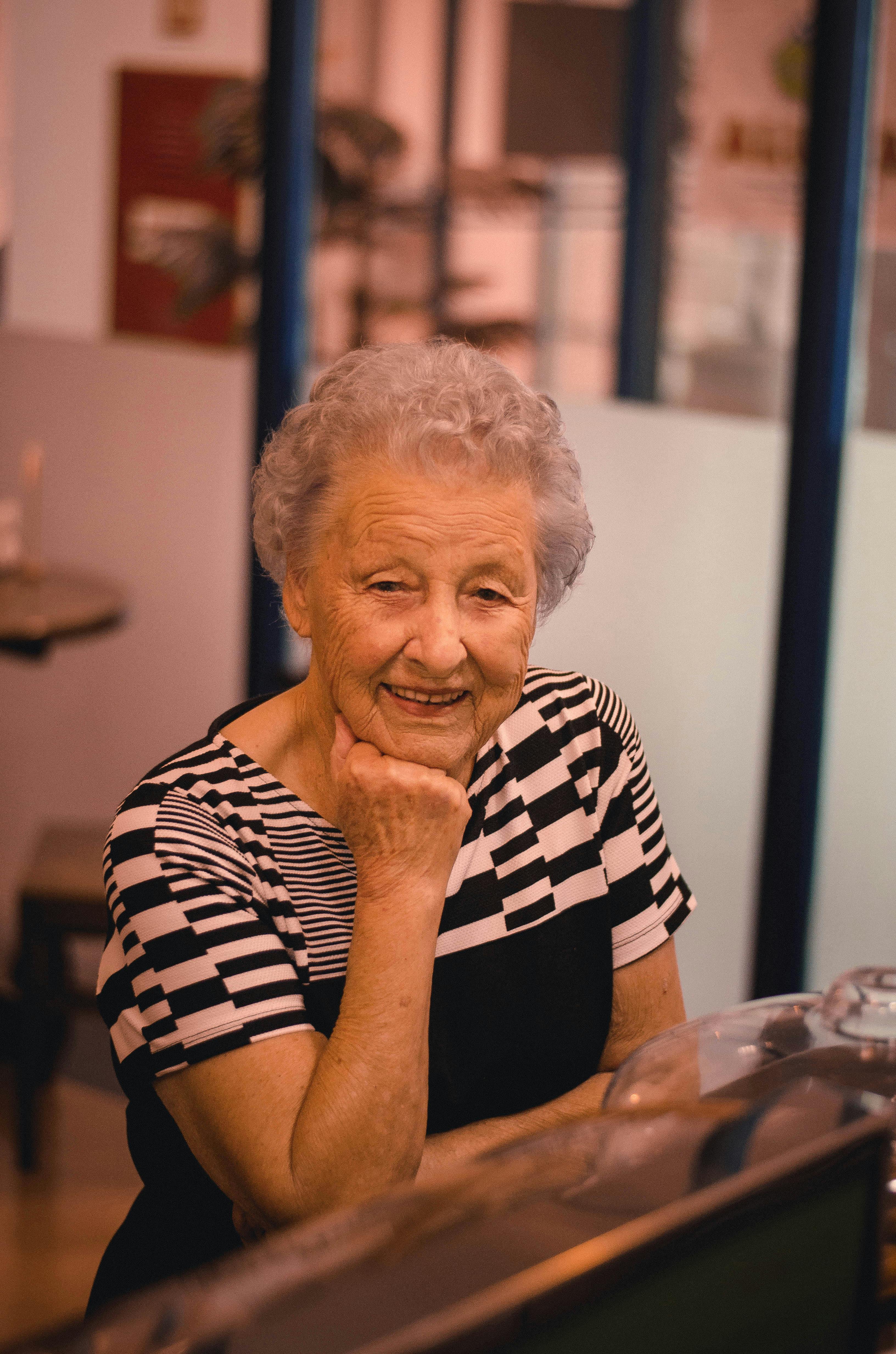 A smiling old woman in the coffee shop. | Photo: Pexels