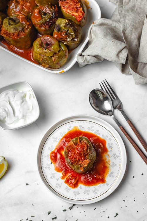 Ground beef and rice stuffed bell peppers baked and served with rich tomato sauce and fresh herbs