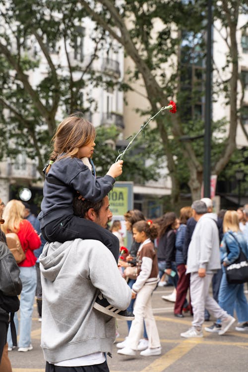 A man and a child are standing in the street