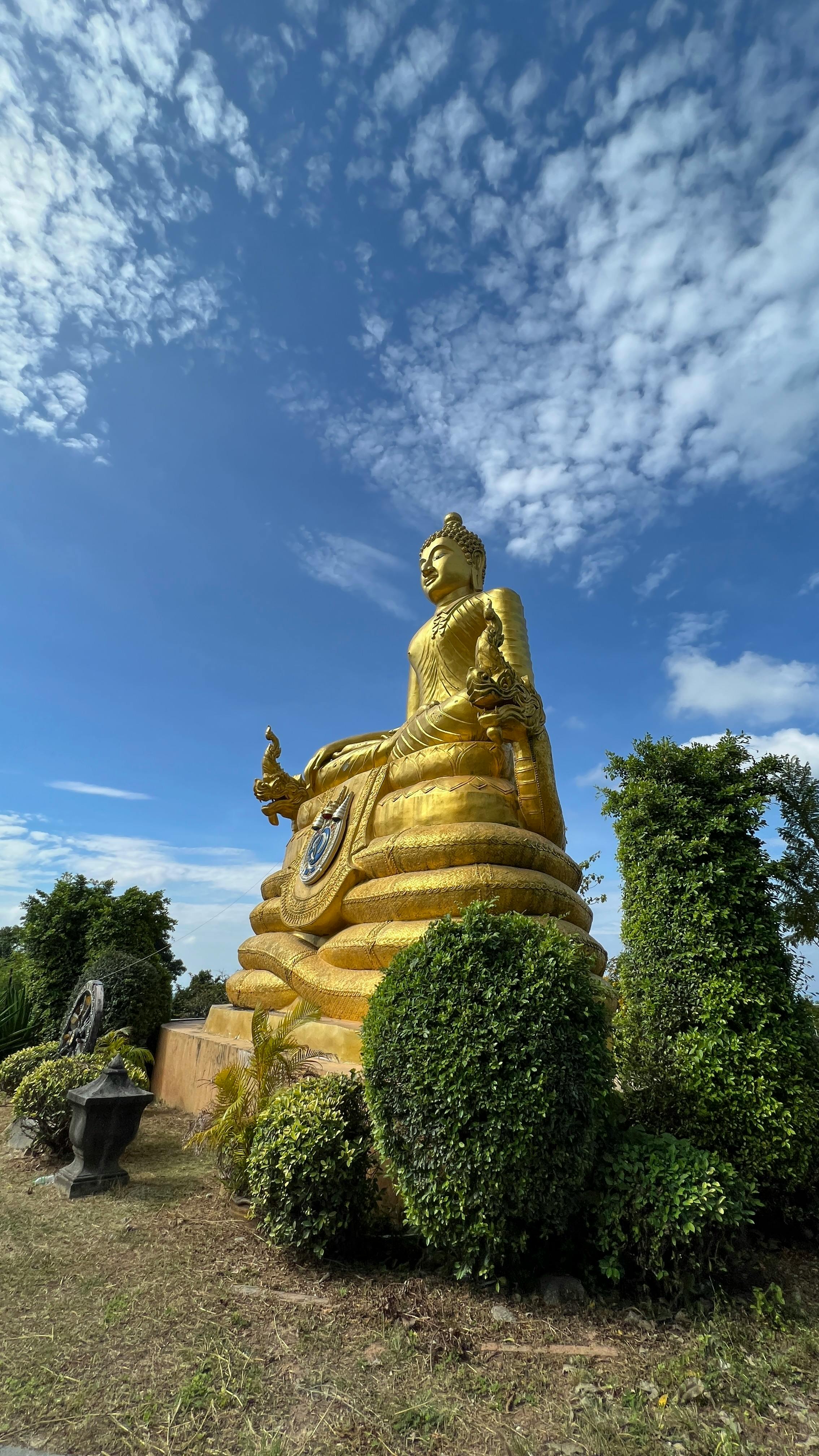 Majestic golden Buddha statue under a clear blue sky in Phuket, Thailand.