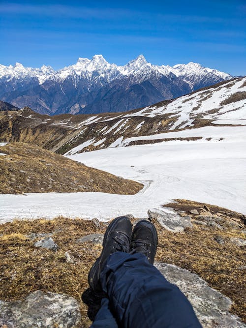A person's feet are resting on a snowy mountain