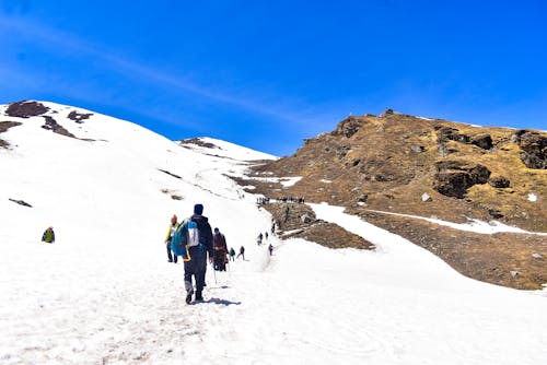 People walking up a snowy mountain with snow on the ground