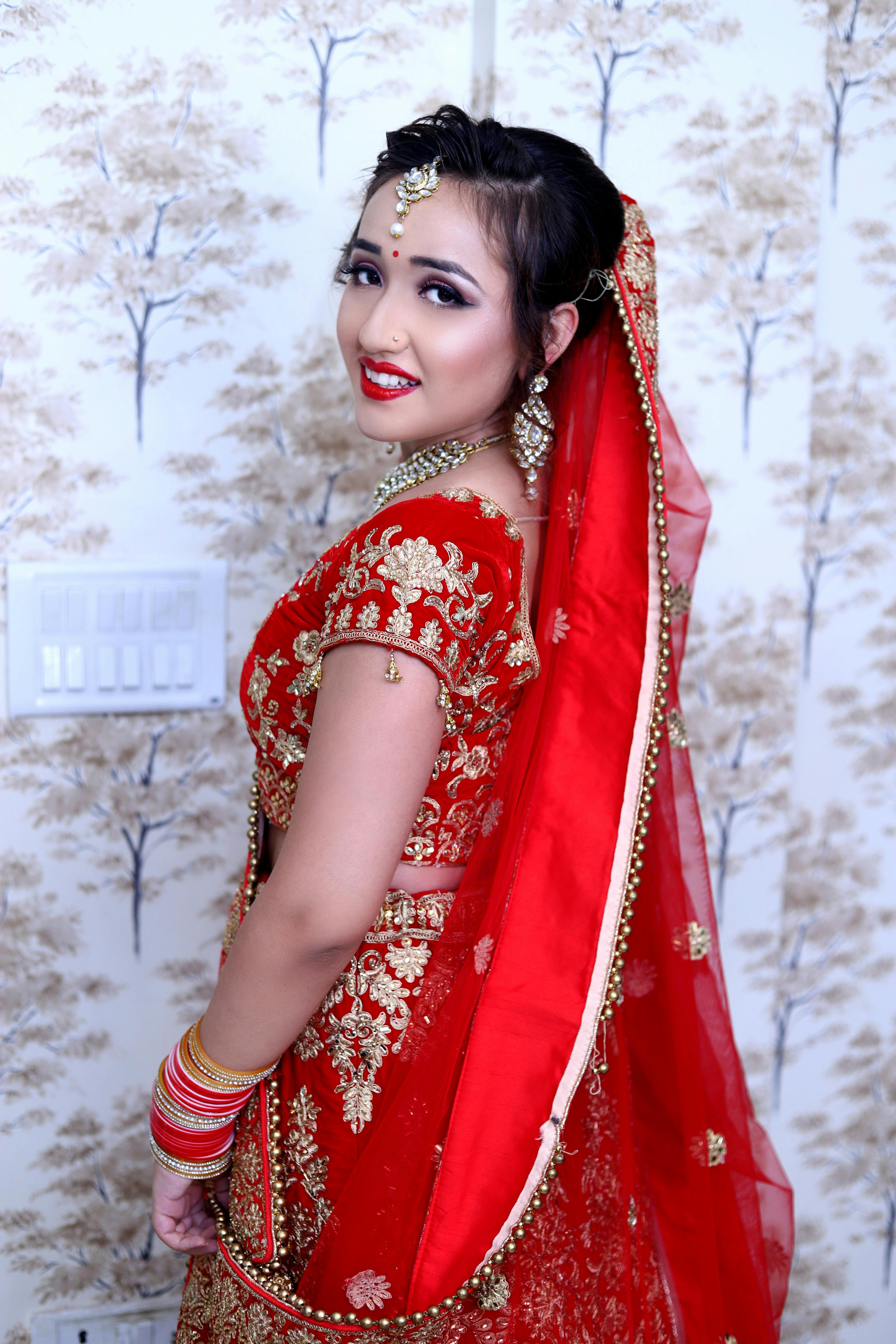 woman wearing red and gold saree dress