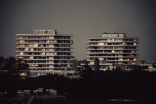 Two tall buildings with lights on them