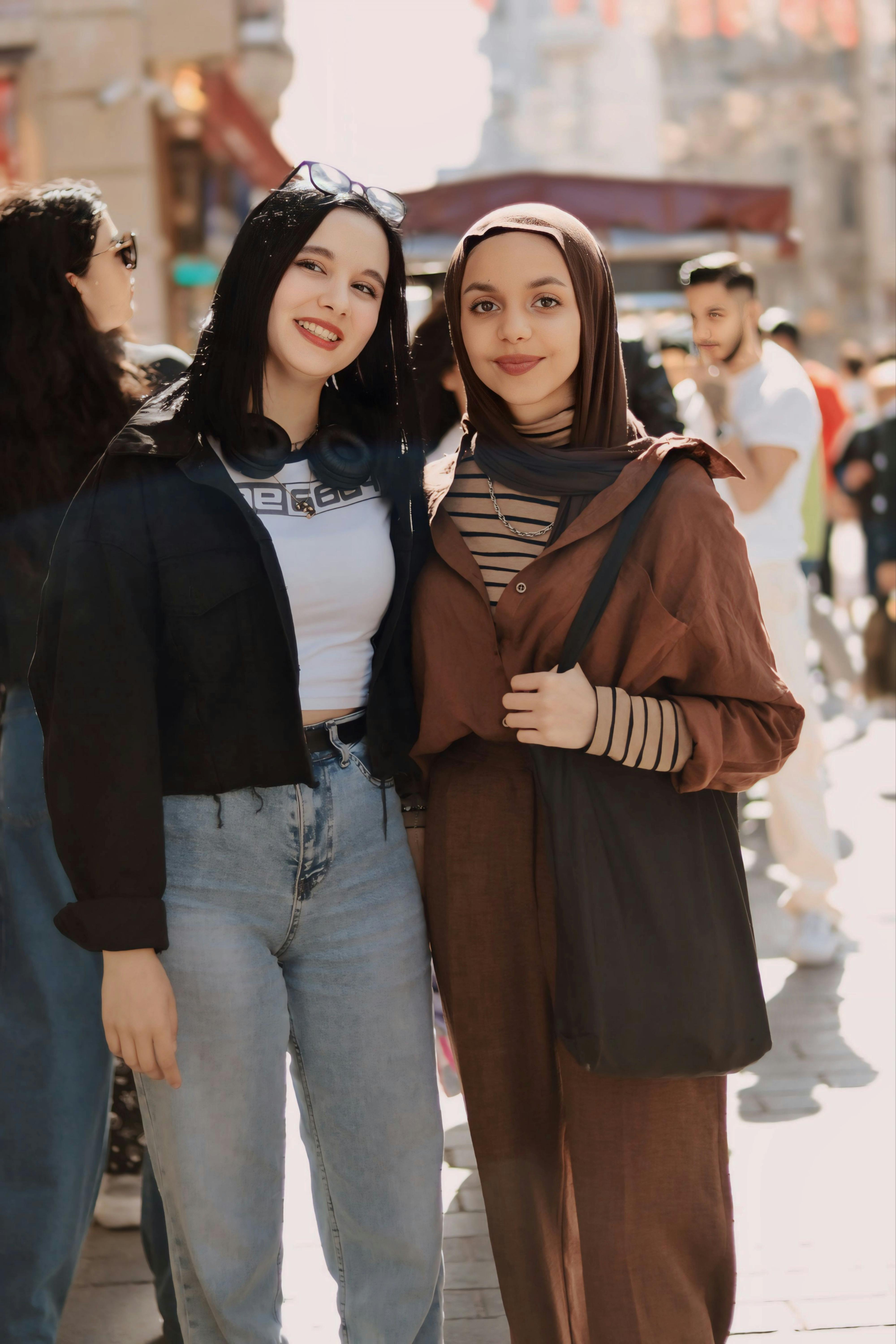 smiling friends posing on the sidewalk