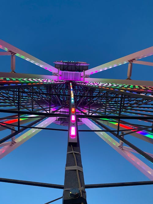 A ferris wheel with colorful lights at night