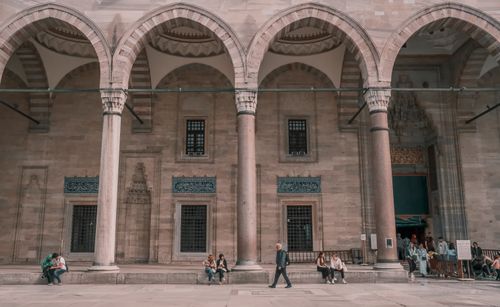Free People in a courtyard of the Suleymaniye Mosque, showcasing Ottoman architecture. Stock Photo