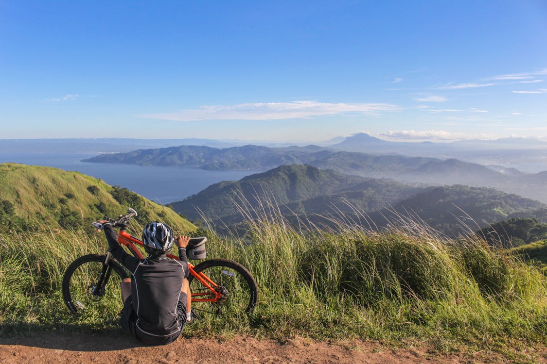 Free man Sitting Beside Bicycle Stock Photo