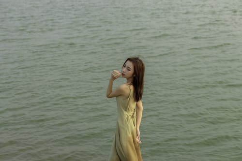 A woman in a long dress standing in the water