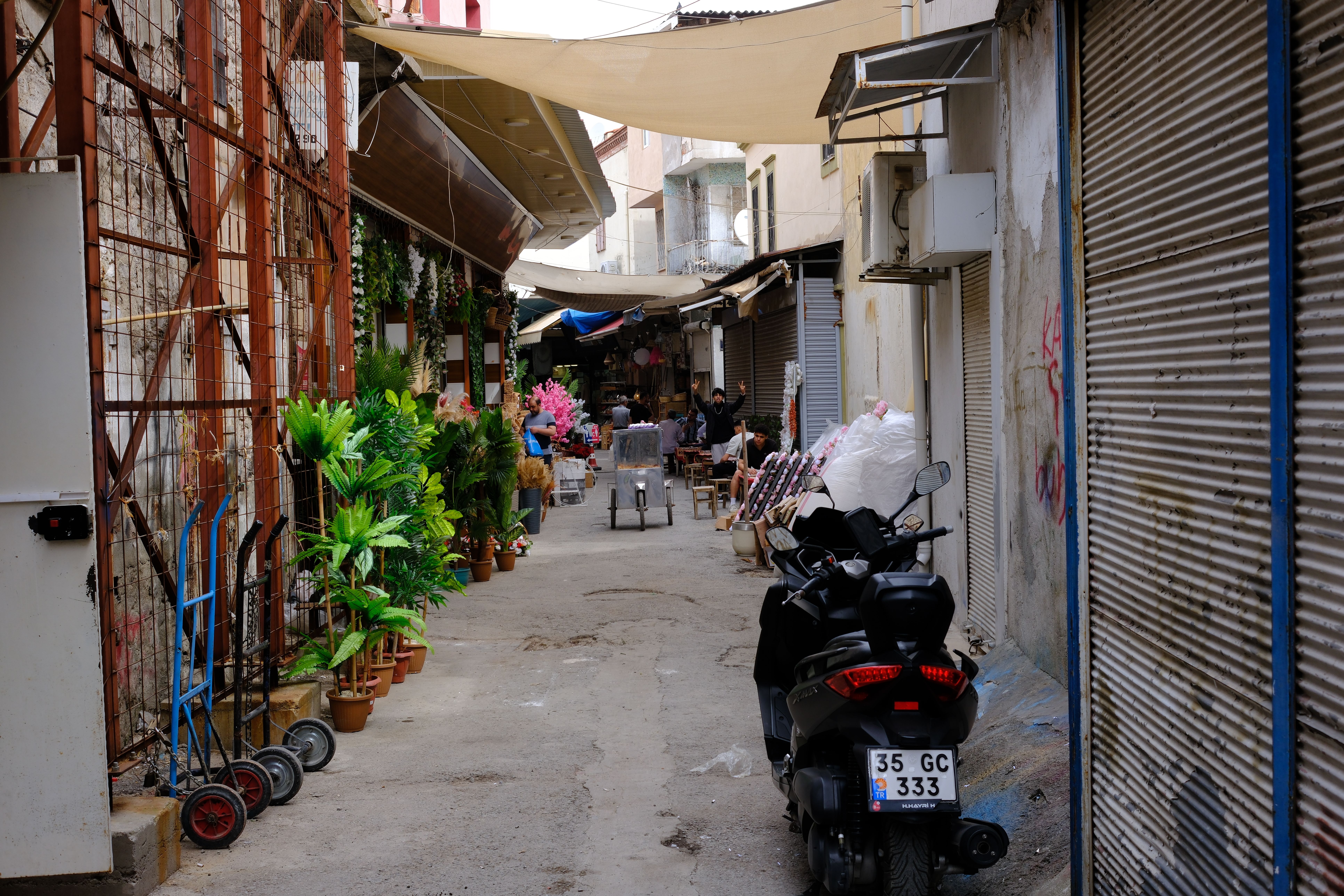 Greengrocer crates and Turkish bakery signs along a narrow shopping street in Lombok Utrecht