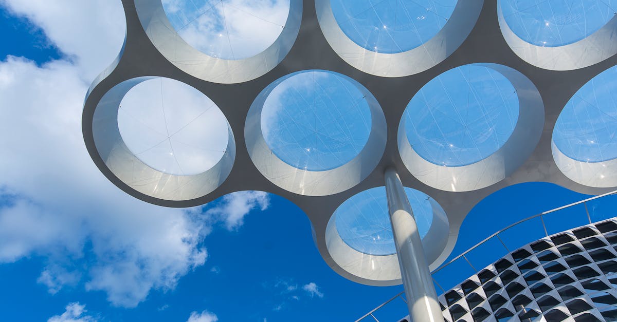 Low angle view of unique modern architectural design in Utrecht, featuring circular roof and clear blue sky.