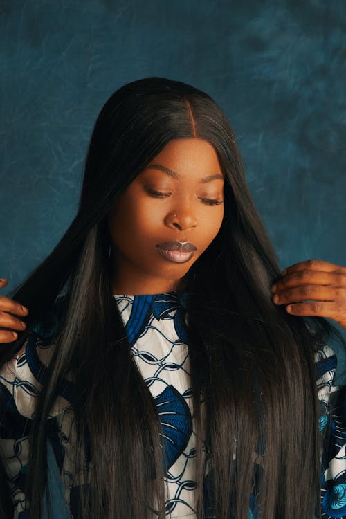 A woman with long black hair and a blue top