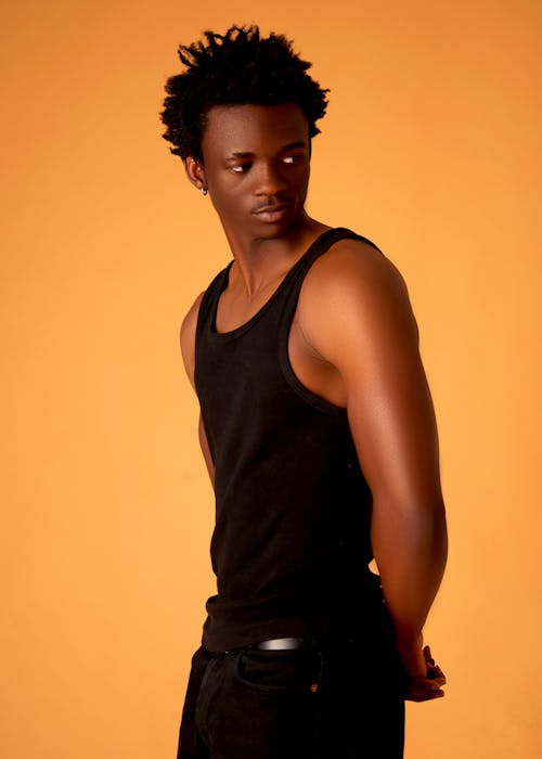 A young man in a tank top posing for a photo
