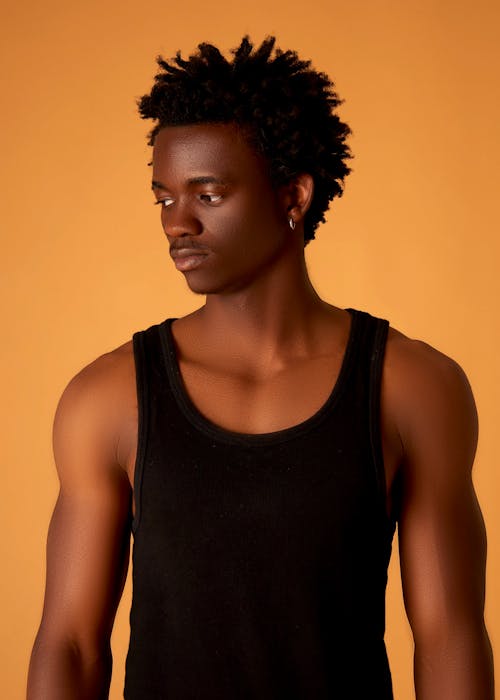 A young man in a tank top and black pants