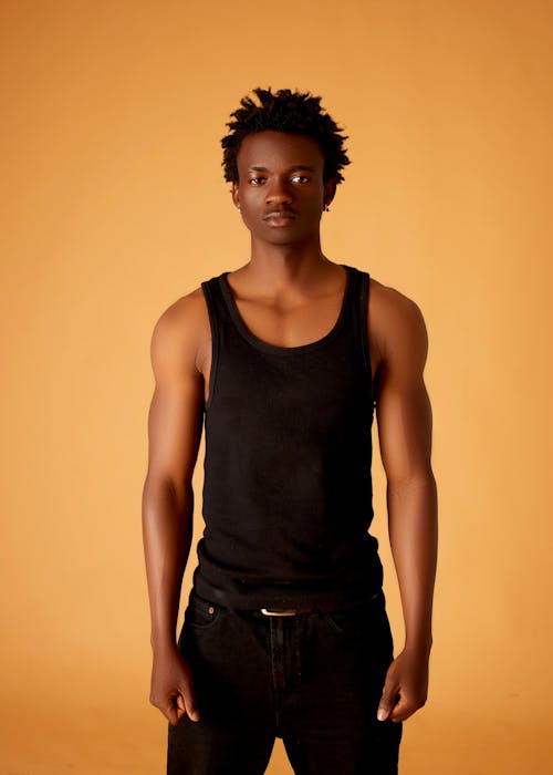 A young man in a tank top and jeans