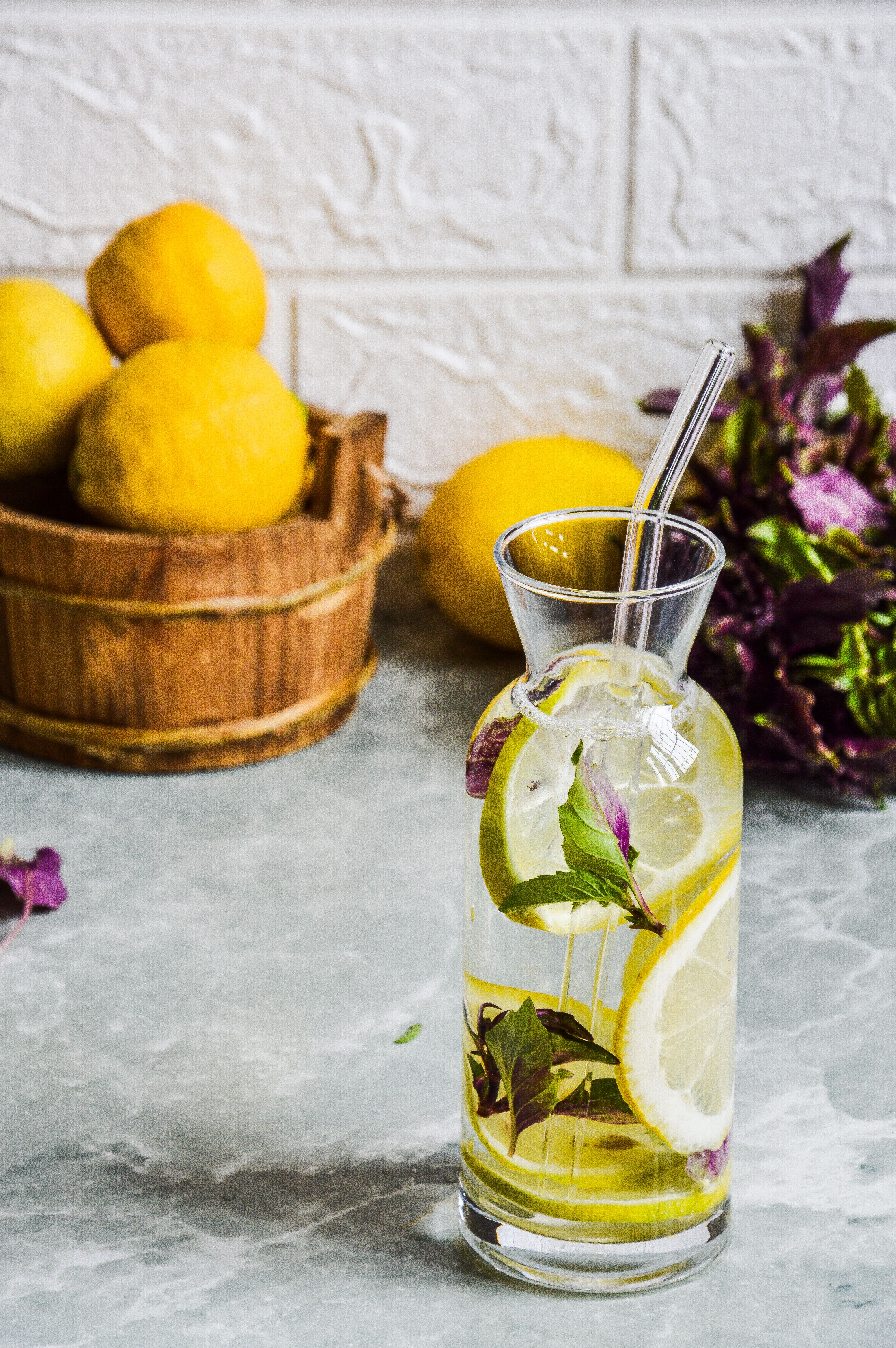 A fresh lemon-infused beverage with herbs served in a glass. Ideal for summer refreshment.