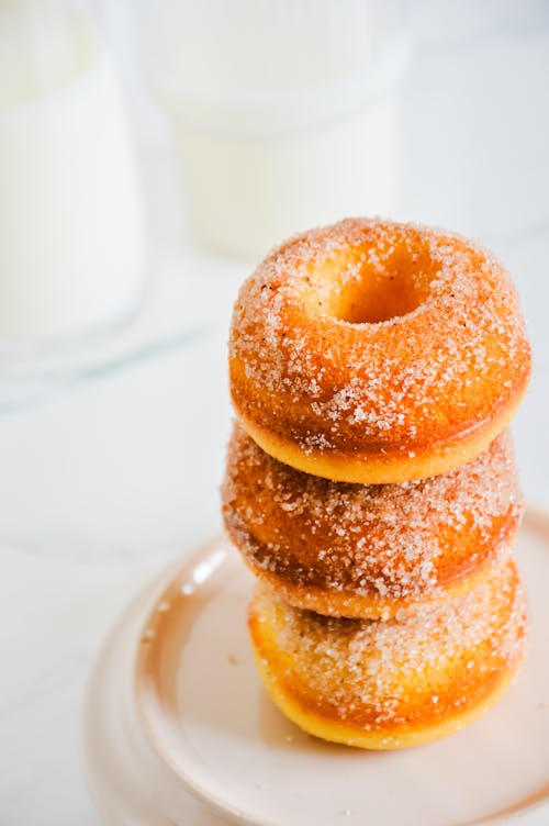 A stack of donuts on a plate with milk