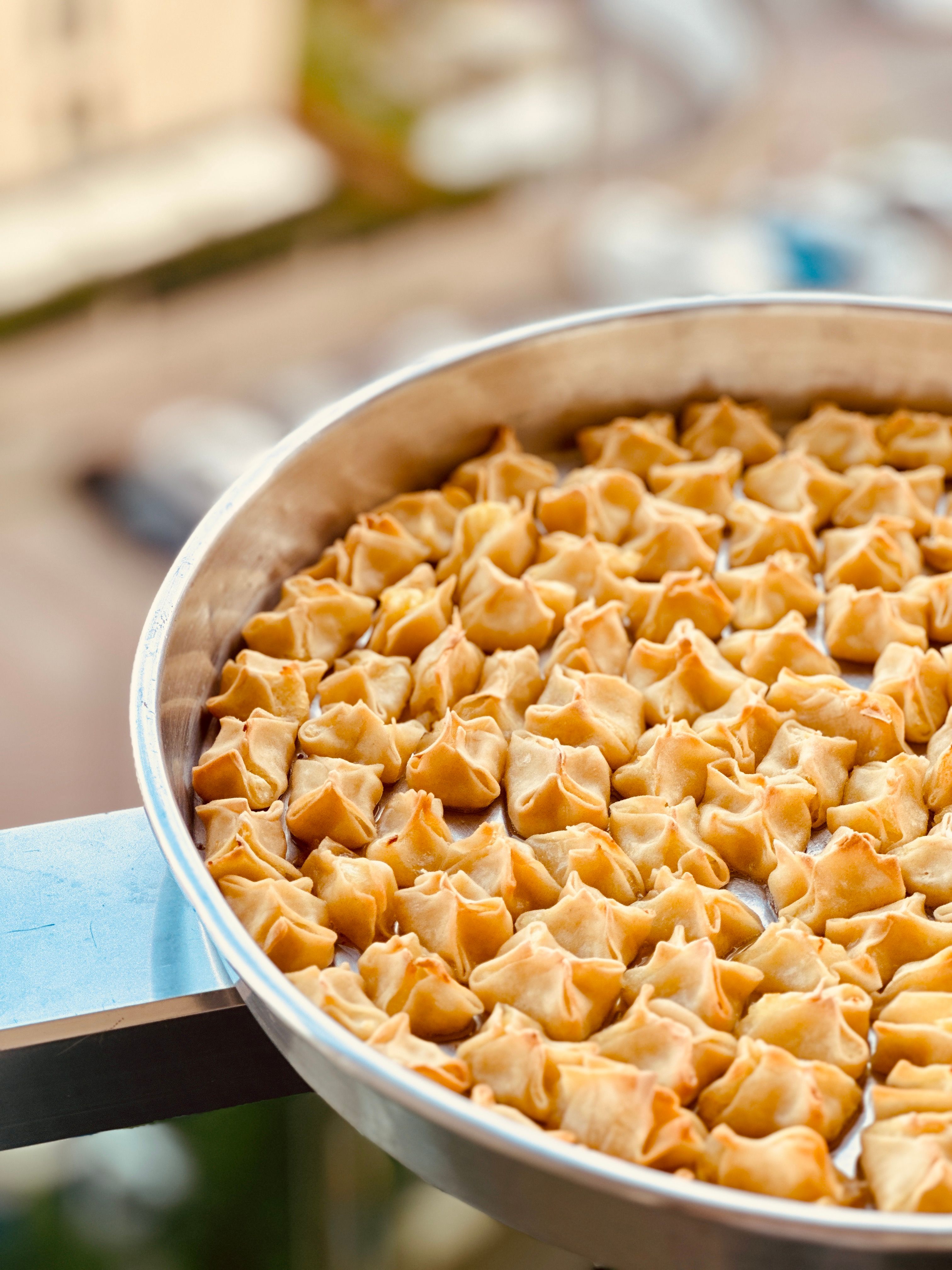 Tray of golden brown dumplings outdoors, capturing essence of homemade cuisine.