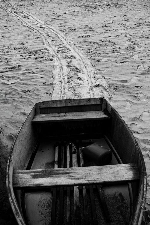 Free Black and white photograph of a wooden boat on a sandy beach in Rio de Janeiro. Stock Photo