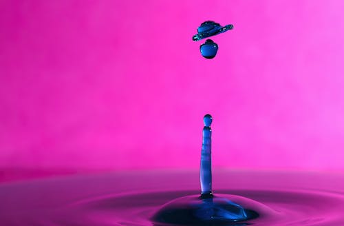 A drop of water with a blue and pink background