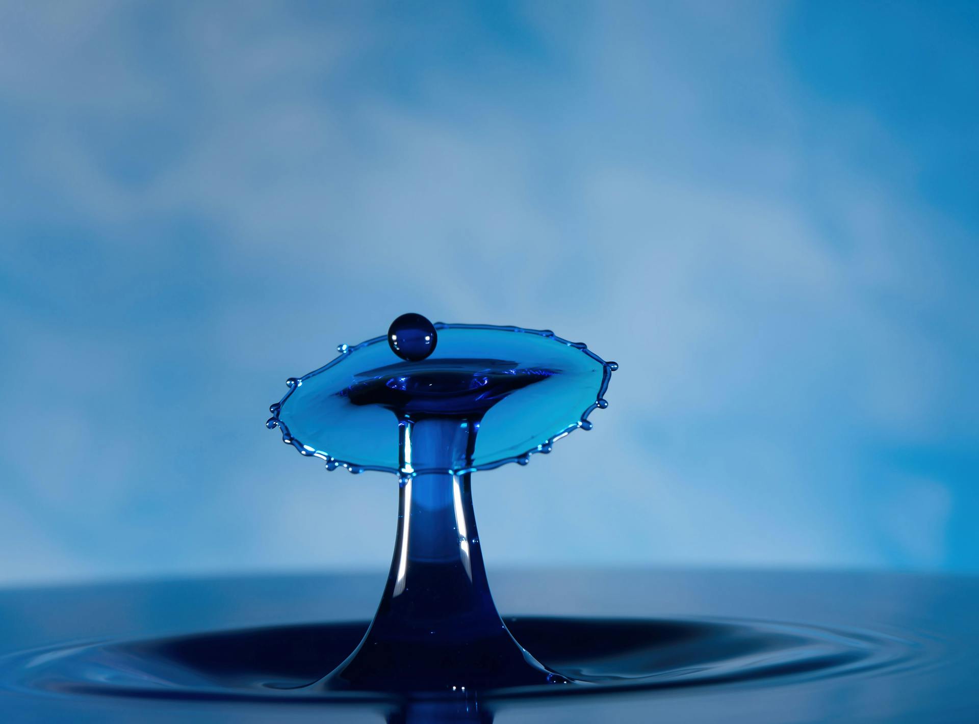 Elegant splash art illustrating a water drop collision in vivid blue tones.