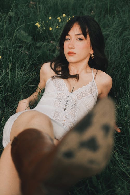 A woman laying in the grass with her feet up