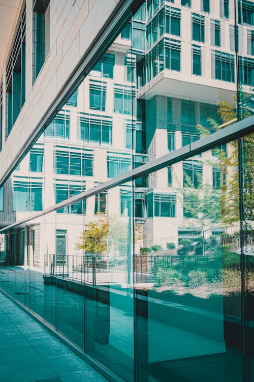 A glass wall with a reflection of a building