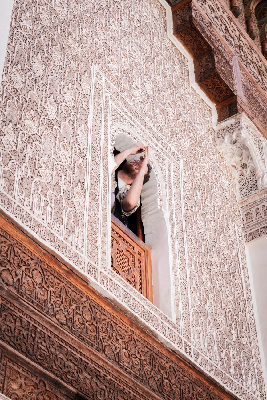 Explore the detailed Islamic architecture of Ben Youssef Madrasa in Marrakesh, featuring ornate carvings and traditional motifs.