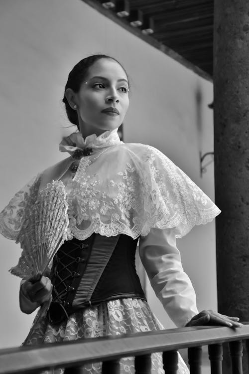 A woman in a victorian dress holding a fan