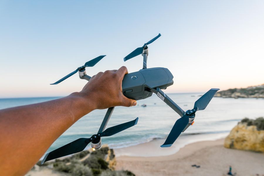 Pilot holding a drone above a beach at sunset for the Cloudpath project