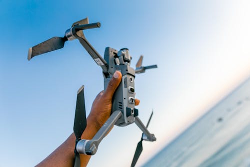 Shallow Focus Photo of Person Holding Gray Quadcopter Drone