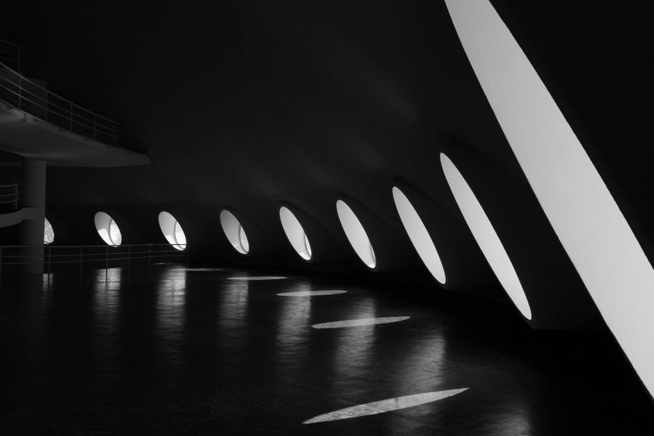 Black and white interior view of a modern architectural space in São Paulo with unique lighting design.