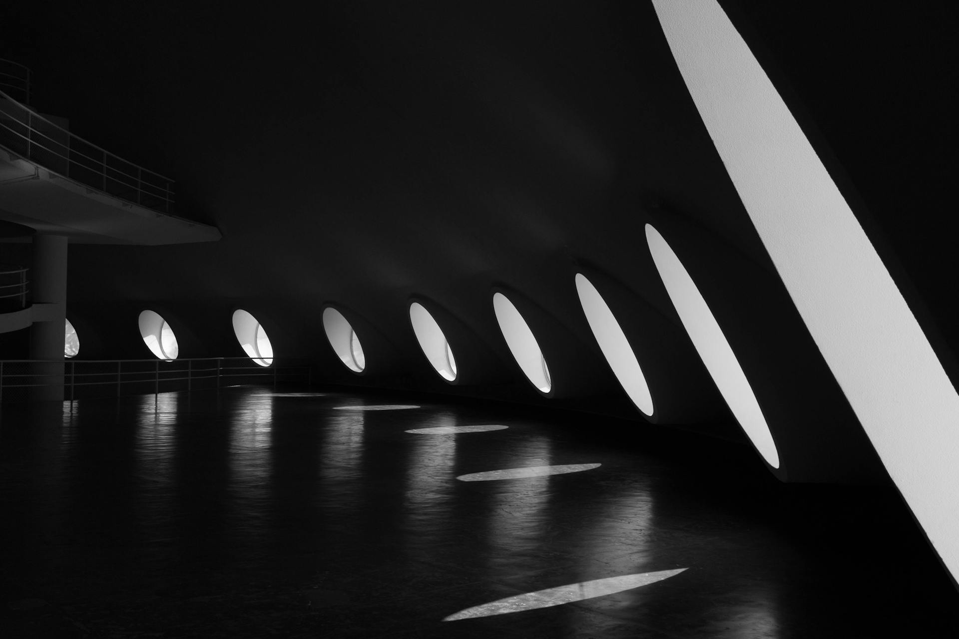 Black and white interior view of a modern architectural space in São Paulo with unique lighting design.