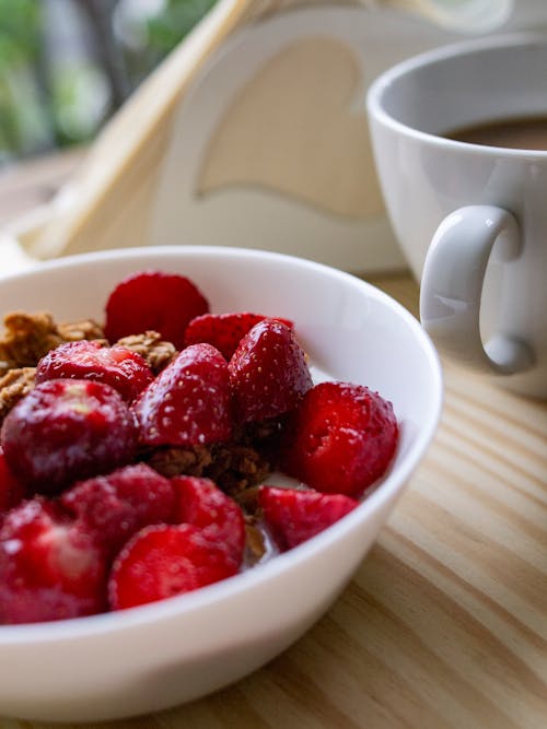 免費 切成薄片的草莓在白色陶瓷碗上的淺焦點照片 圖庫相片