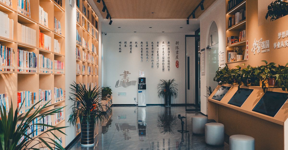 Sleek library interior featuring bookshelves, plants, and modern Chinese decor.