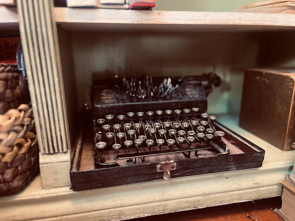 A miniature typewriter sits on top of a shelf