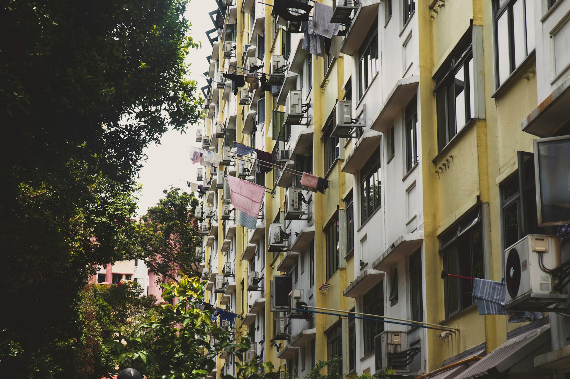 Colorful apartment building facade in urban Singapore with laundry visible, capturing city life.